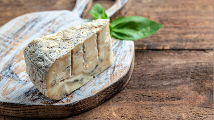 French cheeses blue cheese dorblu, gorgonzola, roquefort on wooden table. Long banner format. top