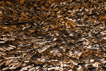 Wood waste recycle. Natural wood scraps, approach to save environment. Planks of wood as wooden texture. Abstract background from sawn wooden boards.