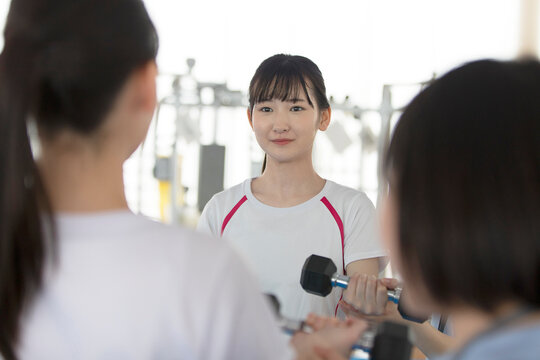 ダンベルを使ってトレーニングする日本人女性