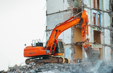 Process of demolition of  building. Excavator breaking old house.