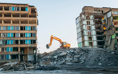 Process of demolition of  building. Excavator breaking old house.