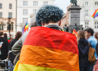Woman with rainbow flag during Krakow Equality March (Pride parade) at Main Market Square. Symbol of the LGBT community.