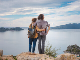 Couple traveler explore ruins castle of Simena with view of sea bay and Kekova Island with famous flooded city. Tourist attractions in Turkey. - obrazy, fototapety, plakaty