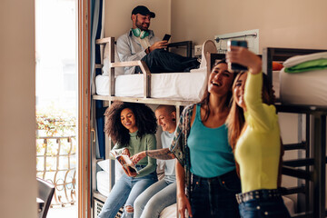 backpackers lifestyle in youth hostel - young people in room with bunk bed - travelers - students in the college dormitory - obrazy, fototapety, plakaty