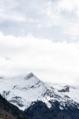 Vertical photo of a snow covered mountain with white cloudy sky in french Pyrenees. Inspirational and positive concept.