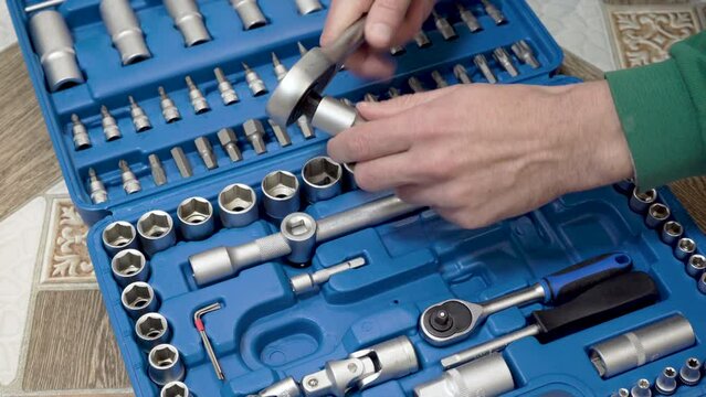 picks up the key tools in the set,the car mechanic takes the keys to repair the car