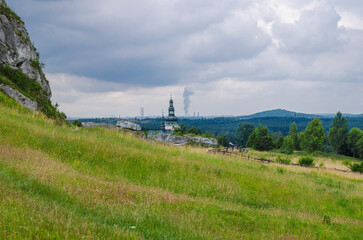 Fototapeta na wymiar Widok na kościół w miasteczku oraz miasto przemysłowe na horyzoncie