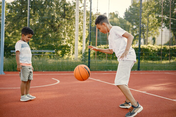 Two brothers playing basketball in basketball court together