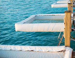 Fototapeta na wymiar Grid overwater sunbed on the beach. Relax and swimming in the sea. Lounge zone for honeymoon.