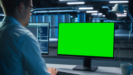 Confident male Data Scientist Works on Personal Computer with Green Screen Mock Up in Big...