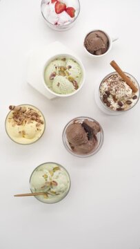 Vertical video: Set of different flavors of ice cream in glasses