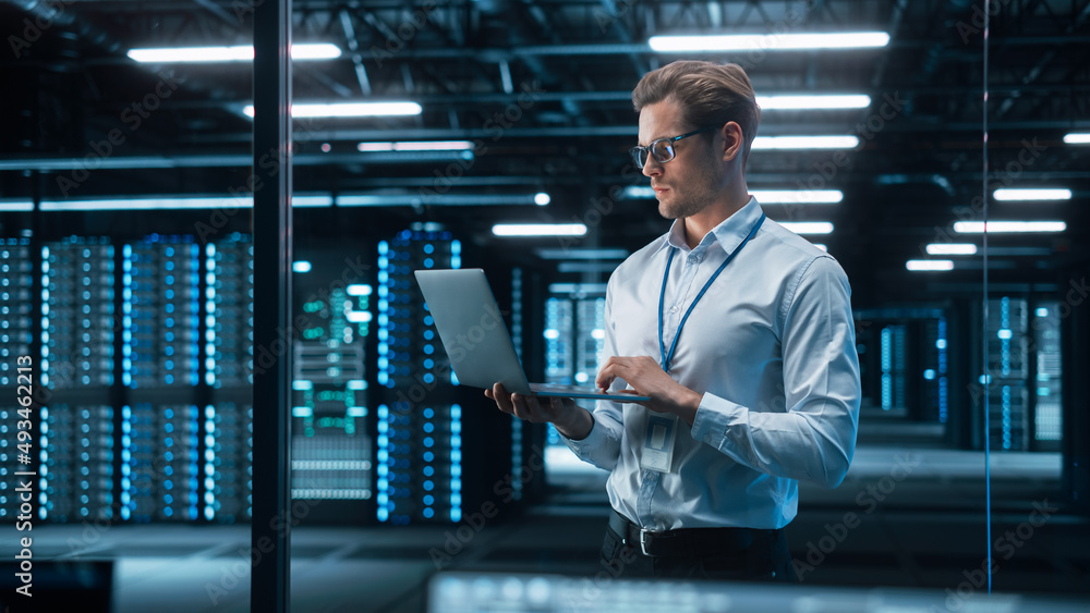 Poster portrait of it specialist uses laptop in data center. server farm cloud computing facility with male