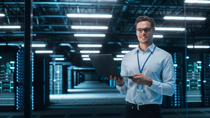 Portrait of Caucasian Male Specialist Using Laptop in Big Data Center. Managing Director Working...