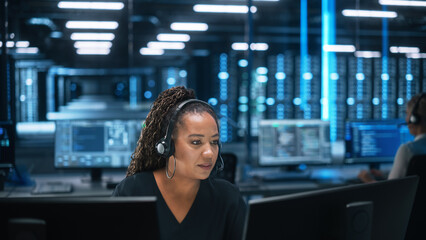 Call Center Office: Portrait of Friendly African American Female Technical Customer Support Specialist Talking on Headset, uses Computer. Client Experience Officer Helps Online via Video Conference - obrazy, fototapety, plakaty