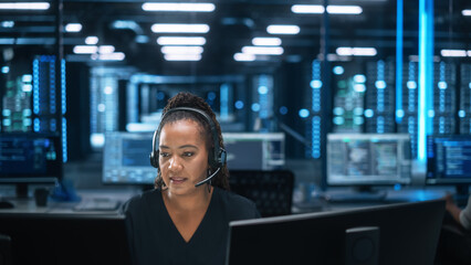 Female Executive Wears Headset Video Calling on Computer at Evening Office. Call Center Agent,...