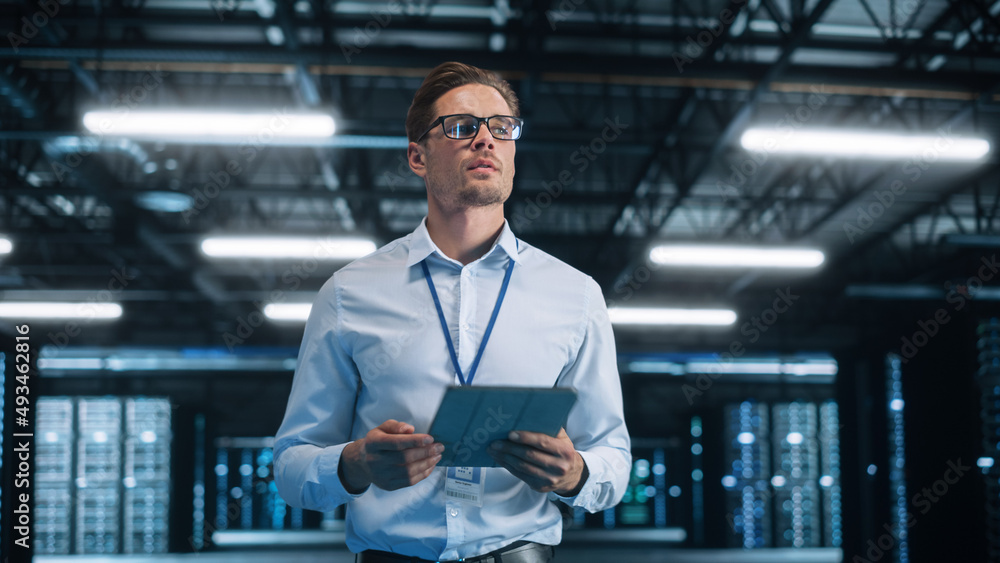 Poster Caucasian Data Center IT Technician Standing at the Server Rack Corridor with a Tablet Computer. He is Visually Inspecting Something while Looking Away. Night Office Concept