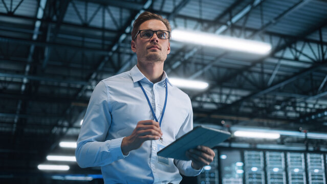 Portrait of IT Specialist Using Tablet Computer in Data Center. Male System Administrator Working with Big Server Farm Cloud Computing Facility. Cyber Security, Network Protection - Powered by Adobe
