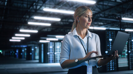 High-Speed Data Transfer and Smooth Server Operation. Female Engineer Programs Something and Looking at Laptop Computer while Works in Dark Modern High-Tech Office. Analytics and Statistics Concept