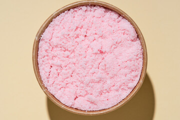 Scented pink bath salt or body scrub. Natural skin care product. Hygienic routine.