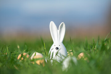 white ceramic rabbit on green grass in a field with eggs