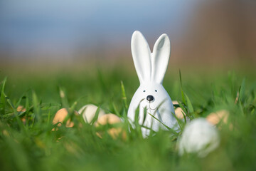 white ceramic rabbit on green grass in a field with eggs