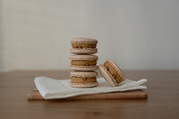 White sweet almond cookies, multicolored with cream, composition on a wooden table.