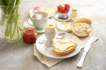 Continental breakfast sweet and salty with buns, cooked egg and a cup of coffee on rustic stone,...