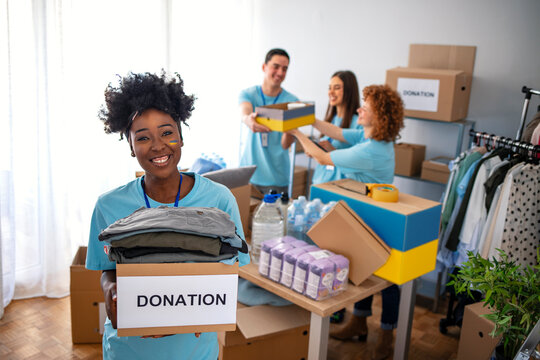 Volunteers Preparing Donation Boxes For People In Need In Ukraine. Donation Clothing For Refugees From Ukraine, Support Of War Victims, Helping People, Charity, A Box With The Ukrainian Flag