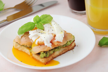 Breakfast with a sandwich with poached egg and avocado