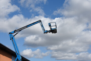 Cherry picker lift platform with telescopic arm on a building site to reach high up in construction...