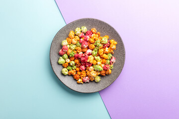 Brightly colored candied popcorn, white background, colored popcorn, colored background