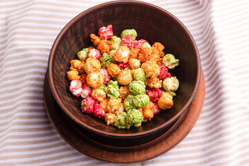 Brightly colored candied popcorn, white background, colored popcorn, colored background