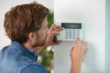 handsome young electrician installing alarm © auremar
