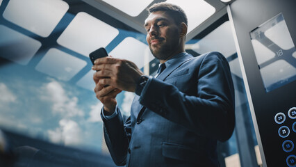 Successful Businessman Riding Glass Elevator to Office in Modern Business Center. Handsome Happy...
