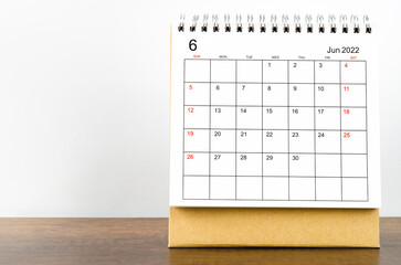 June 2022 desk calendar on wooden background.