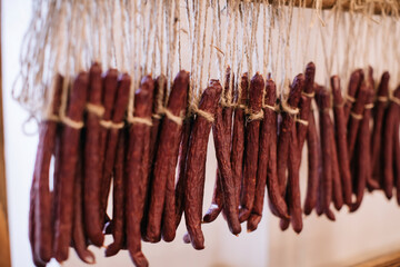 Smoked sausages on a rope. Meat snacks at a holiday party