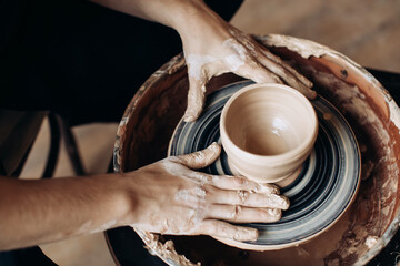 Potter makes a clay jug on a potter's wheel. Handmade
