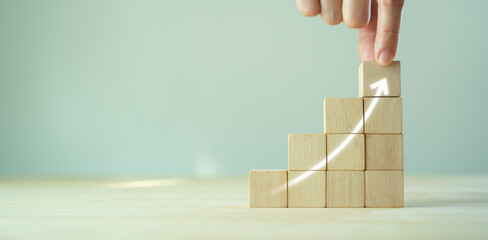 Growth and success concept.  Business common goals and strategies. Hand puts wooden cubes  with...