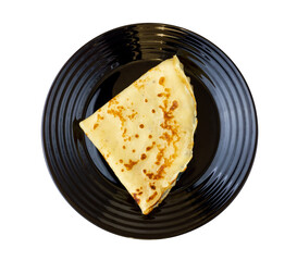 Pancake on a black plate. View from above. Isolate on a white background.