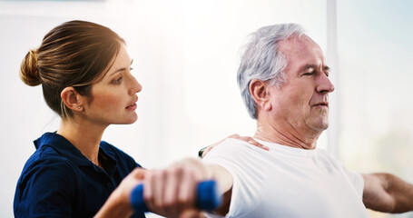 Fototapeta premium Regular exercise is vital as you grow older. Shot of an attractive young female physiotherapist working with a senior male patient.