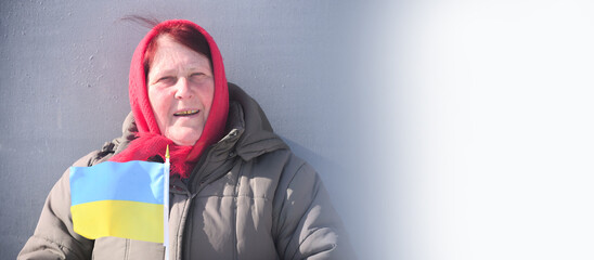 Portrait of old Ukrainian women of 60 years old holding flag of Ukraine and white space for text, patriot of Ukraine,no war in Ukraine