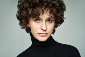 Portrait of brunette with curls wear high neck jumper