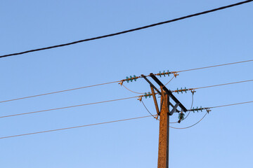 Lignes électriques aériennes avec câbles apparents, sur ciel bleu.