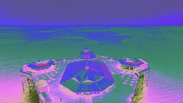 Amusement Arcade And Restaurant Bar On Llandudno Pier Overlooking Seascape In North Wales, United Kingdom. aerial pullback, thermal camera shot