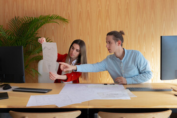 Young engineers working together on a project while making sketches