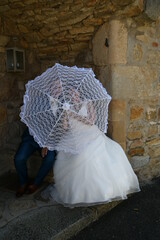 Couple de mariés pendant leur mariage avec une ombrelle 