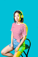 Young asiatic woman wearing wireless headphones listening music