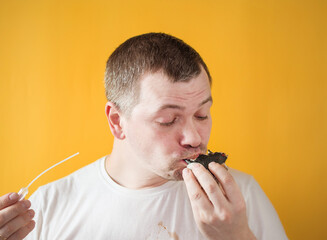the guy eats asian food on a yellow background,