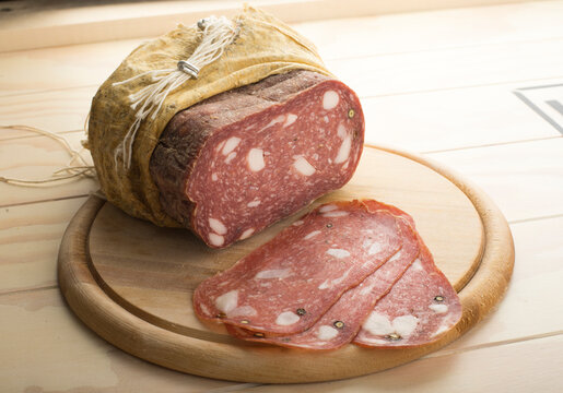 Spinata Salami in cloth served on a wooden plate