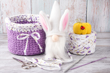 a knitted basket made of knitted yarn and a dwarf with rabbit ears. workshop of needlework and...